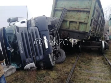 Фото: В Кузбассе грузовик упал на бок после столкновения с вагонами 1
