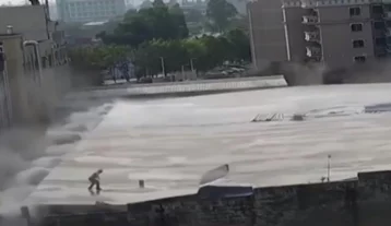 Фото: В Китае здание обрушилось под ногами стоявшего на крыше рабочего 1