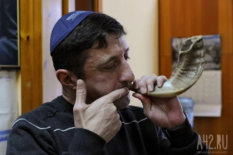 Председатель общины Олег Асташенко дует в шофар – еврейский ритуальный духовой инструмент