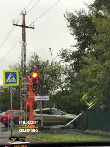 Фото: В Кемерове автомобиль снёс дорожный знак и врезался в забор после ДТП 1