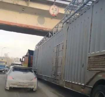 Фото: КамАЗ не проедет: в Кемерове фура застряла под мостом 1