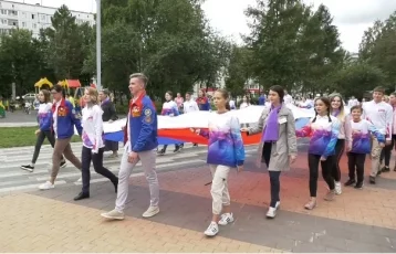 Фото: В Кемерове 100 волонтёров пронесли 56-метровый флаг России 1