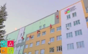 В Кемерове заметили Дедов Морозов-альпинистов. Они вручали подарки детям через окна