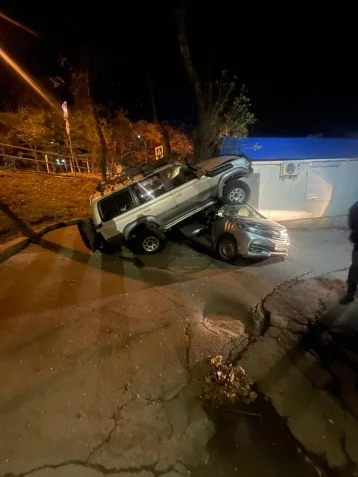 Фото: Во Владивостоке женщина за рулём внедорожника слетела с дороги и заехала на крышу легковушки 1