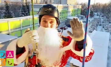 Фото: В Кемерове заметили Дедов Морозов-альпинистов. Они вручали подарки детям через окна 3