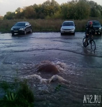 Фото: «Вода затопила тротуар и хлещет из колодца»: в Кемерове на Комсомольском проспекте прорвало трубопровод 1