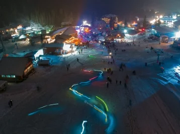 Фото: В Шерегеше сотни туристов с разноцветными фонариками спустились с горы 1