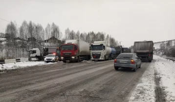 Фото: На кузбасской трассе из-за снежного наката собралась пробка из грузовиков 1